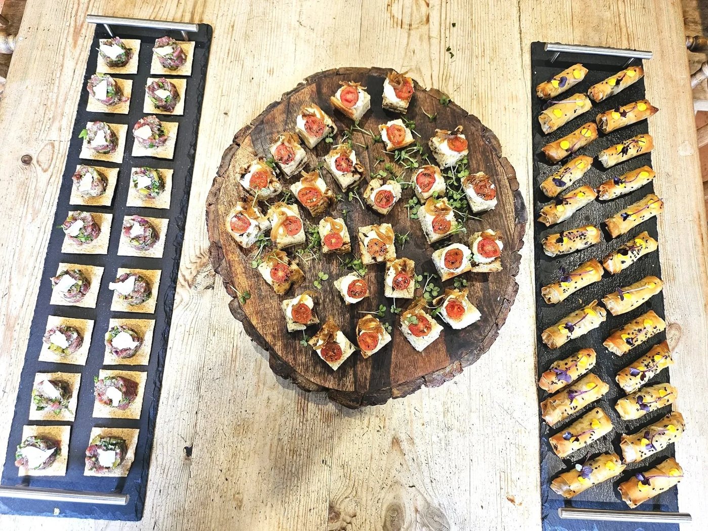 Canapés laid out on a wooden board by House of Vida Catering